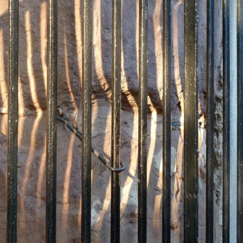 t30581: semi-abstract photo (railings casting shadows on sandstone wall) by Ewart Shaw